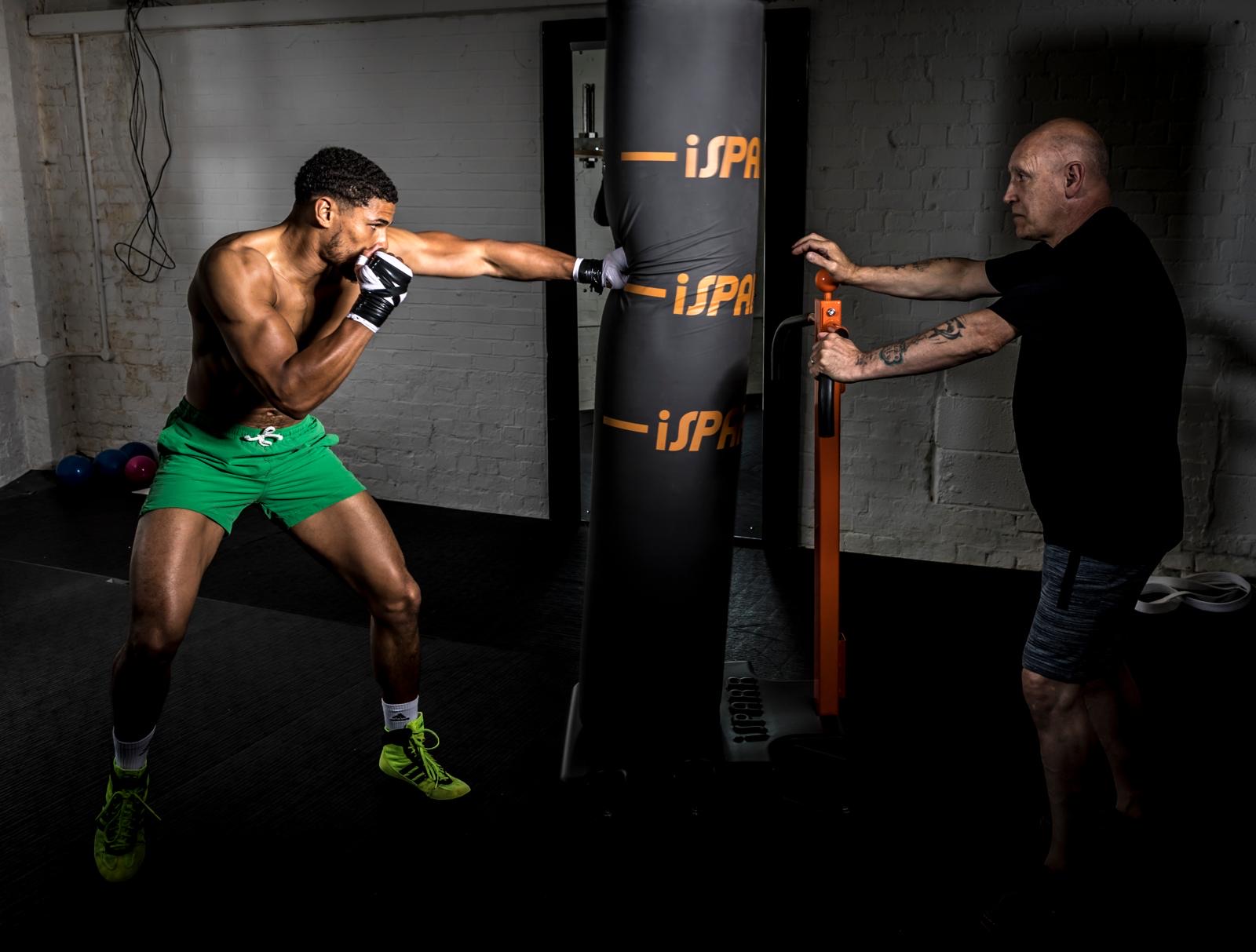 Boxer punching an iSPARR bag held by a coach