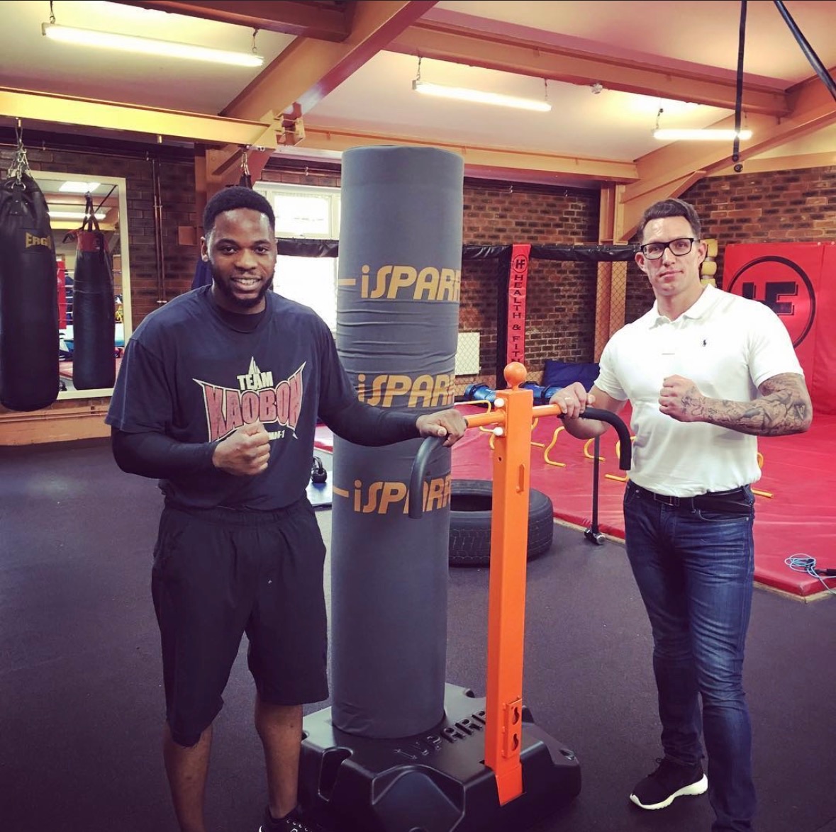 Coaches standing either side of an iSPARR bag in a gym